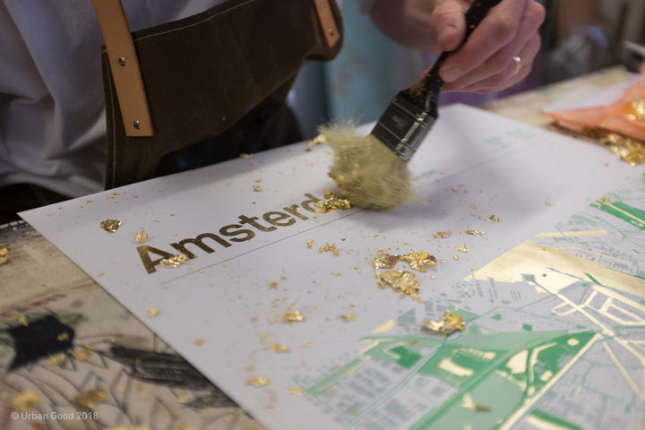 Gold leaf being brushed onto the title of Urban Good’s handmade Amsterdam map print.